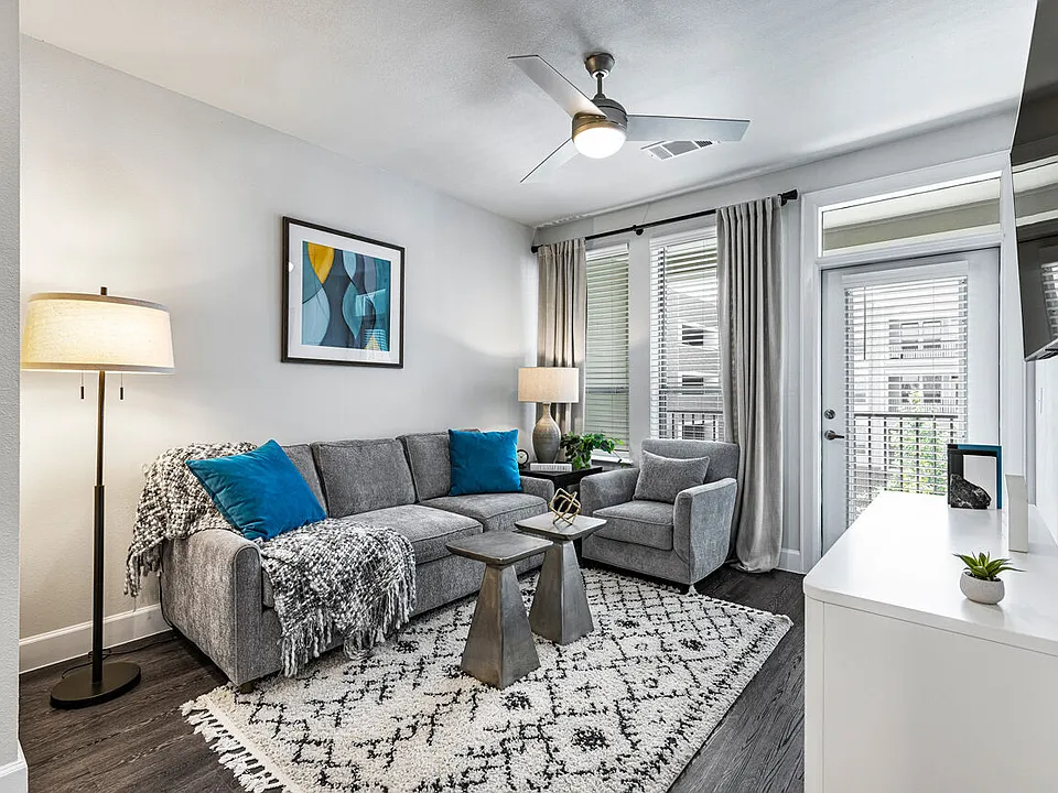 Living room with gray sectional, blue accent pillows and patio door