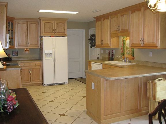 Kitchen with custom cabinets, tile floors, and bar area