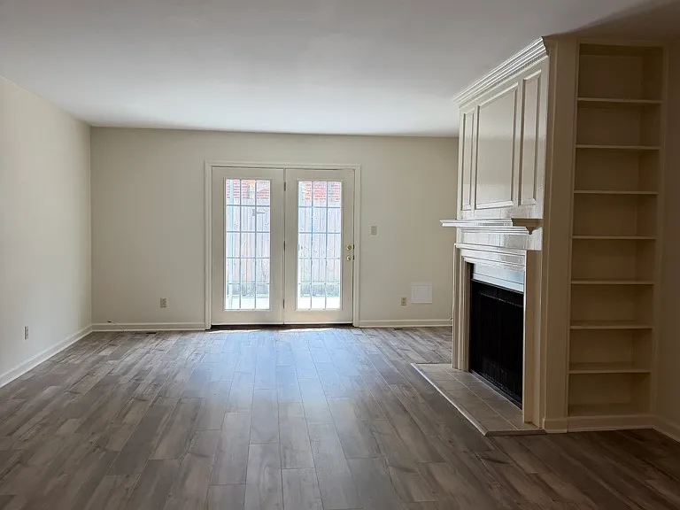 Pretty living room/ dining room with gas log fireplace, atrium doors to private patio, pretty built ins.