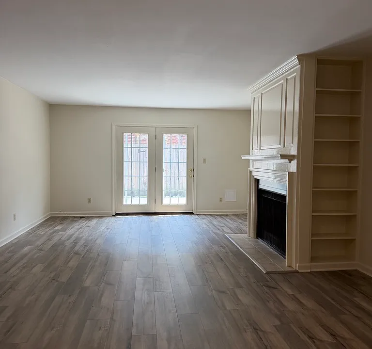 Pretty living room/ dining room with gas log fireplace, atrium doors to private patio, pretty built ins.