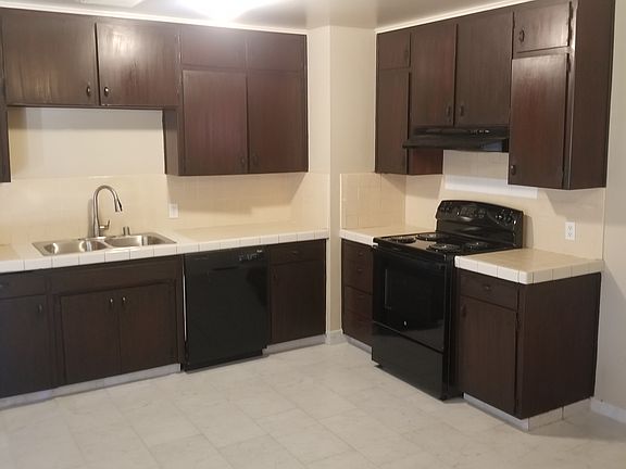 Kitchen with new stove, new sink, and new porcelain tile floor, including dishwasher and garbage disposal.