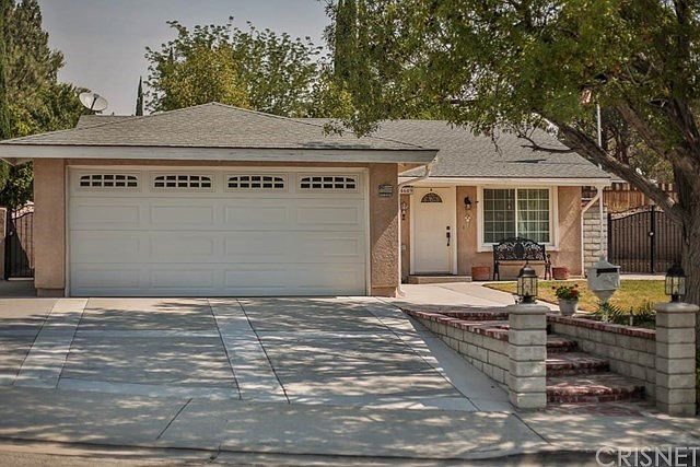 Front of house with stamped concrete driveway, rol