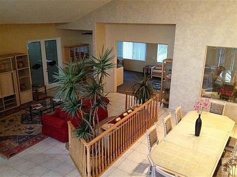 Night view looking from staircase into dining room, living room and extended living area.