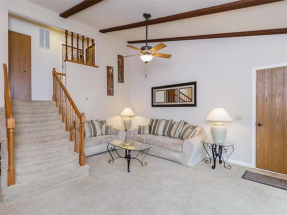 Vaulted living room open to upstairs hallway and looks down to family room with cozy fireplace providing desirable open floor pl