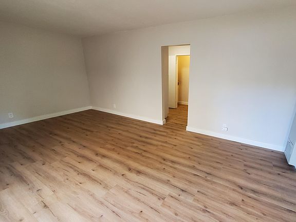 Main living space leading to hallway with kitchen, bathroom, and closet access