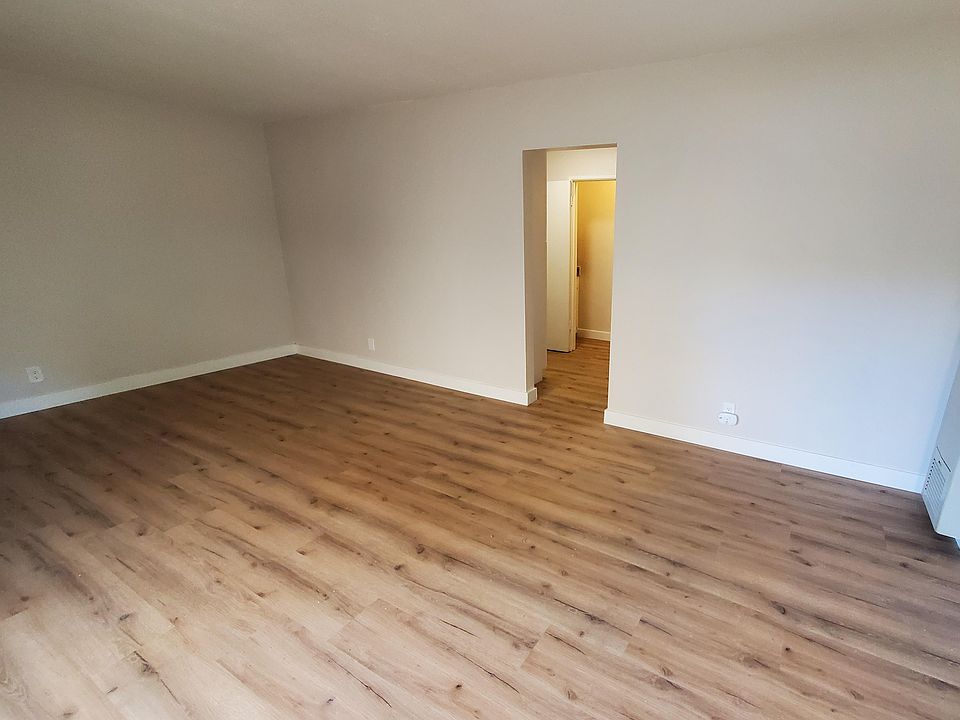 Main living space leading to hallway with kitchen, bathroom, and closet access