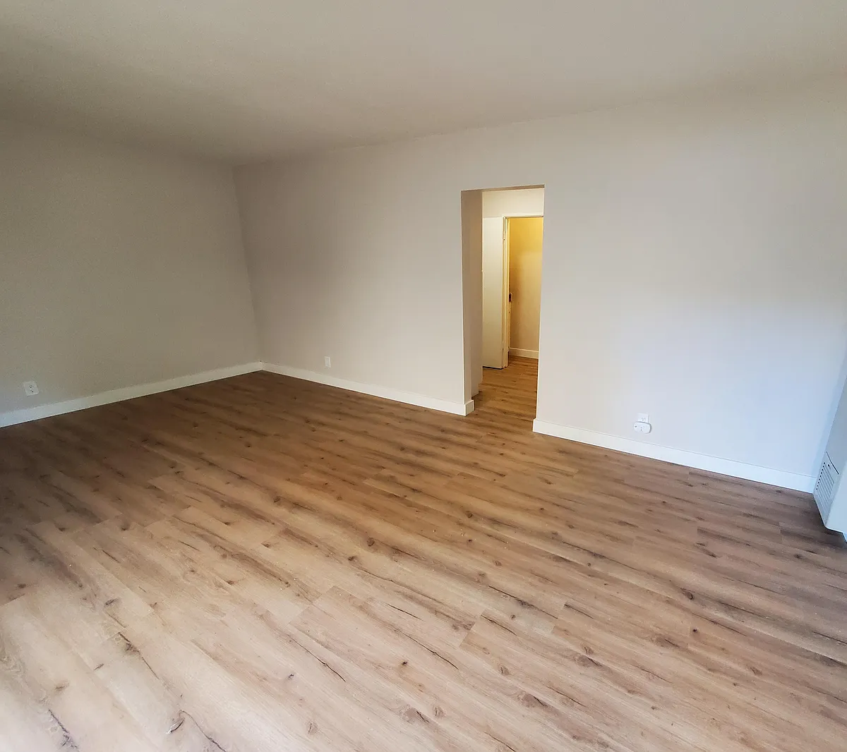 Main living space leading to hallway with kitchen, bathroom, and closet access - 1247 Armacost Ave #1