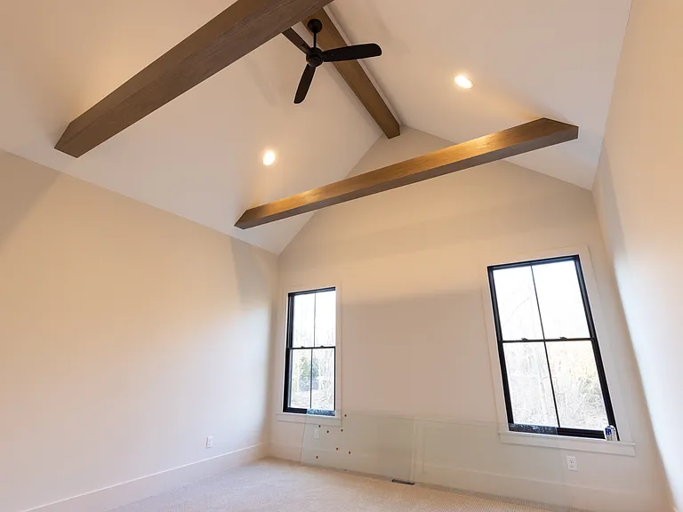 Master bedroom. Vaulted ceiling with fan and exposed wood beams.