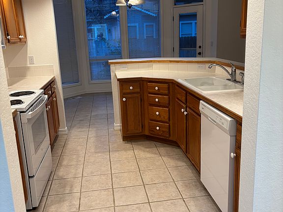 Kitchen, with travertine tiled flooring.