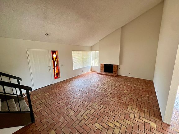 Living room with fireplace, custom stained glass by local artist and upgraded terracootta floors