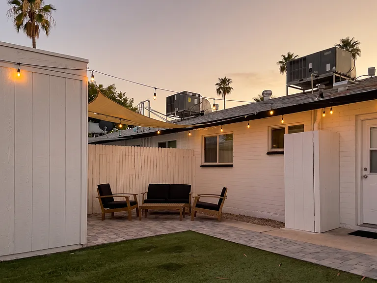 Private fenced back yard with string lights