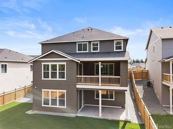 Rear elevation shows all three floors including lower walk out patio from fully finished basement as well as walk out deck with fireplace on main level.