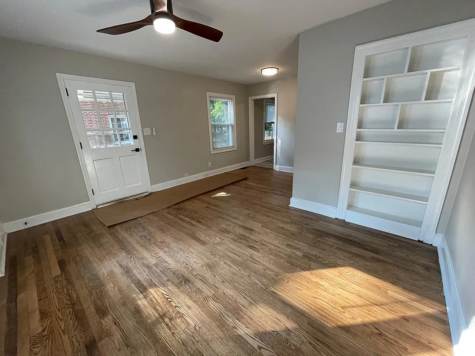 Living Room with built in bookcase, hardwood flooring, and modern ceiling fan