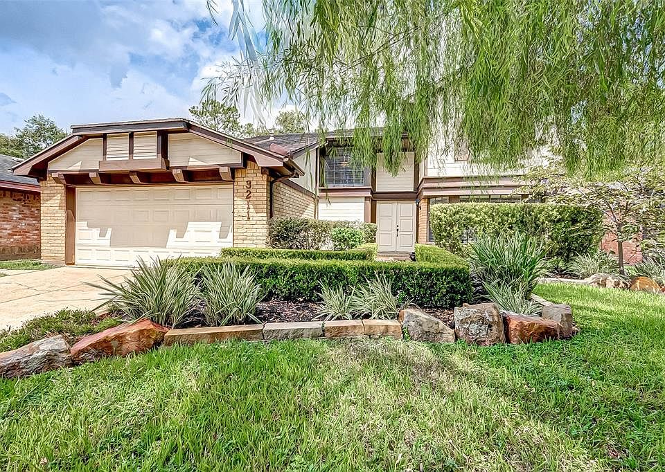 Gorgeous 2-story home with beautiful mature landscaping, rich green shrubs and tranquil Weeping Willow tree.