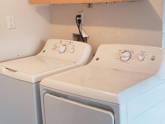 Washer/dryer in garage with shelving