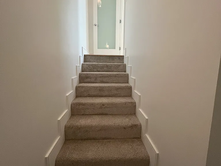 Stairway from second floor family room to garage entry landing