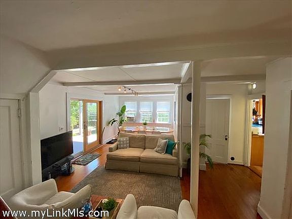 Open living dining area with glass sliders leading to the front porch