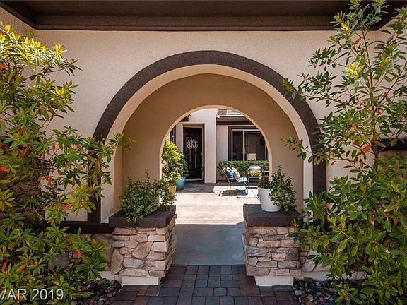 Exterior is accented by mature landscaping, stacked stone accents, and fresh paint