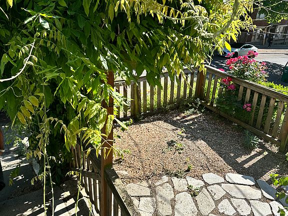 Front patio that leads to side yard, gated for dog run.