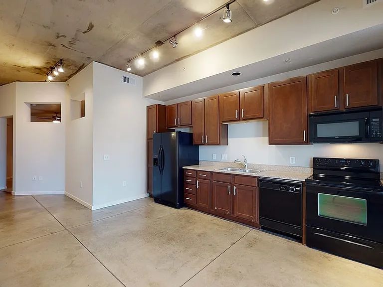 Apartment kitchen with granite countertops and polished concrete flooring