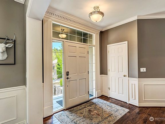 Grand Foyer With Custom Lighting Fixtures And Newer Hickory Hardwood Floors.>