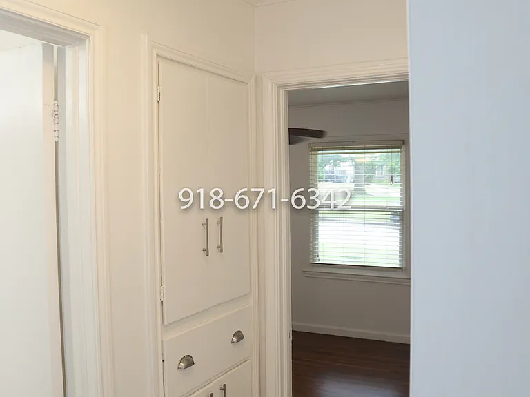 View from primary bedroom looking past bathroom door to the left and into the 2nd bedroom.