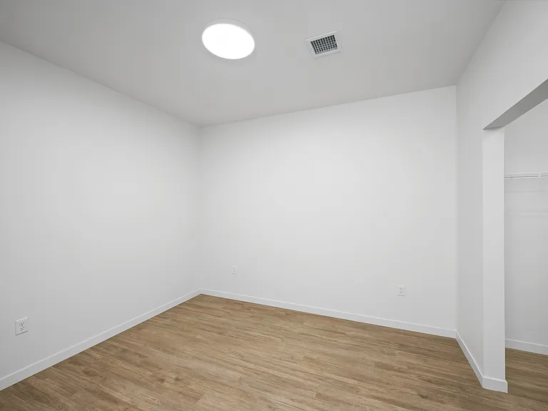 Bright and airy empty room with sleek hardwood floors and a built-in closet, ready to be personalized. Bright and airy empty room with sleek hardwood floors and a built-in closet, ready to be personalized.
