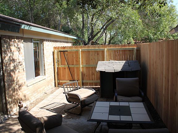 Back yard view of the patio table and dog house