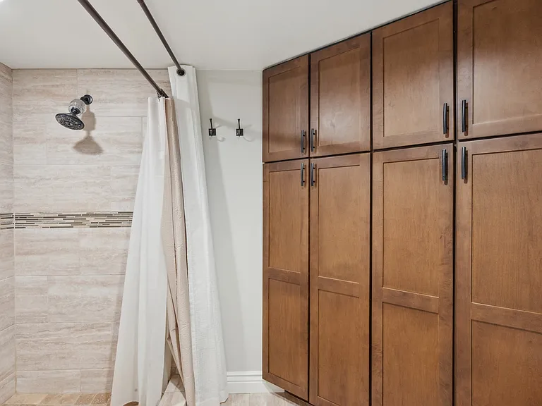 Private toilet/ shower area with floor to ceiling storage.