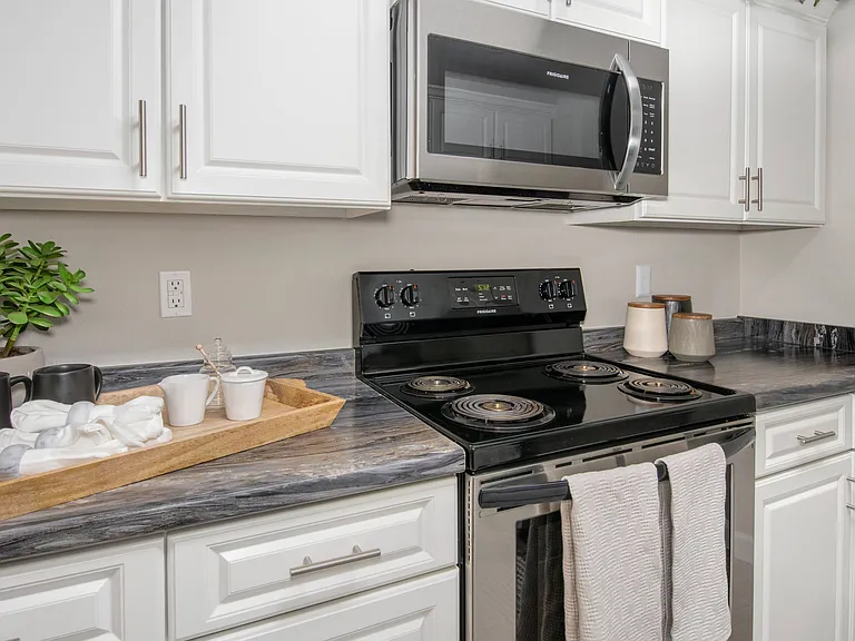 Enjoy bright, modern kitchens with white cabinetry and stainless steel appliances, professionally operated by Highlands Vista Group.