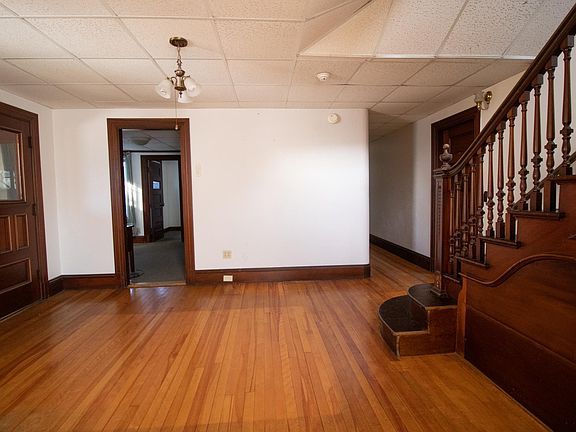 First floor entry with view of office and grand stairway.