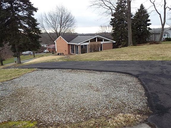 View of property from the outbuilding showing the paved driveway and exterior rear of home.