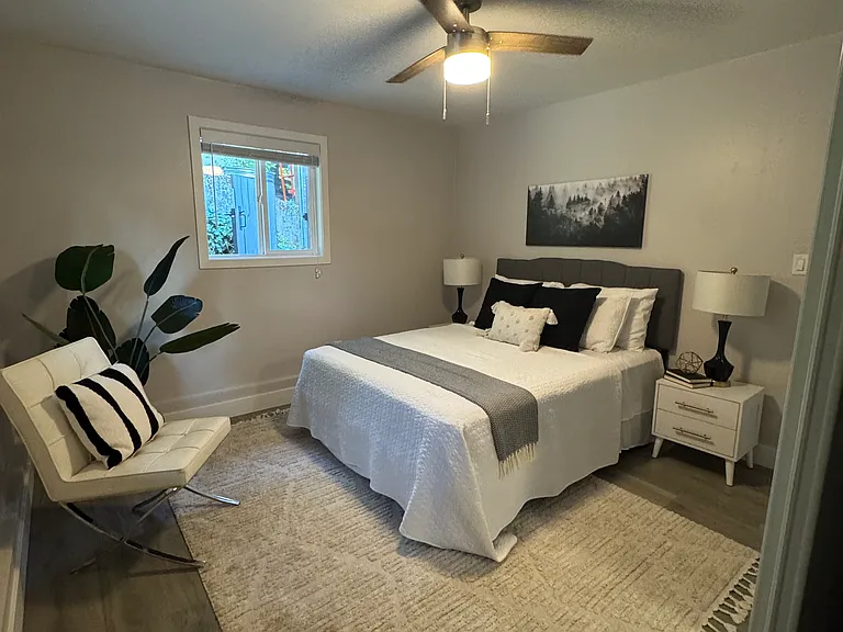 Bright bedroom with dual windows, updated flooring & large mirrored closet.