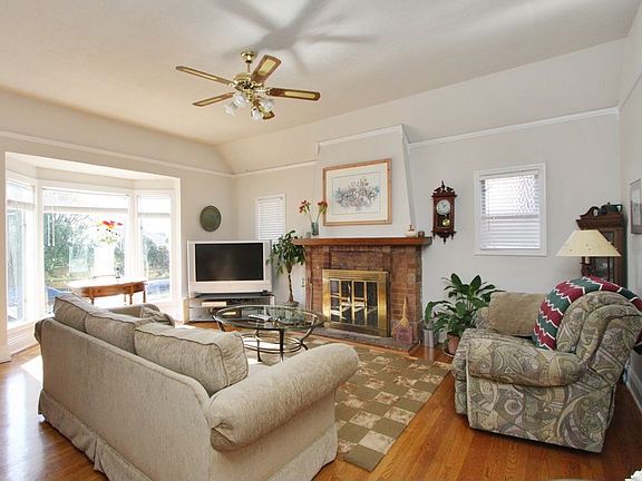 view of living room with fireplace and bay windows
