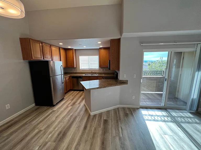 View of the kitchen, balcony and mountains in the distance.
