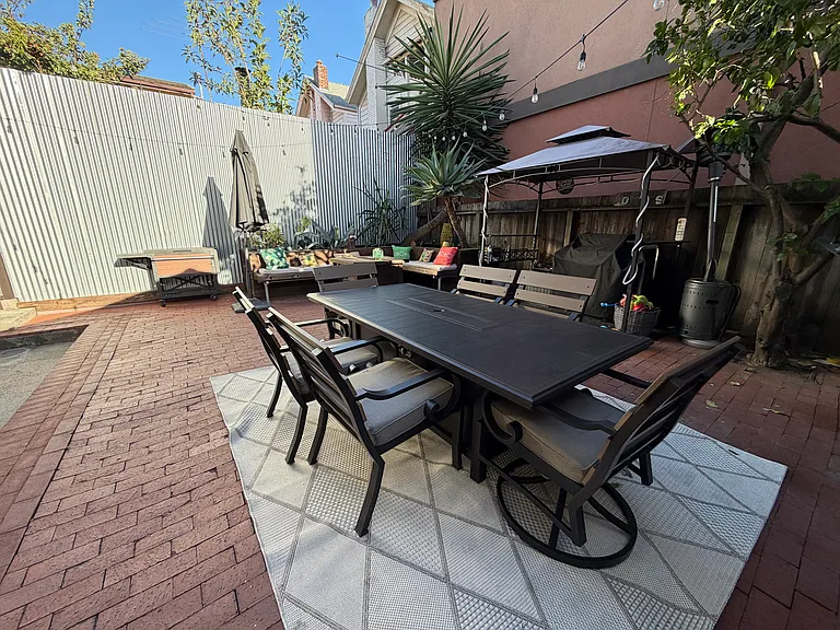 Enjoy the Shared Backyard Featuring an Outdoor Fire Table, Comfortable Seating, and a BBQ Area.