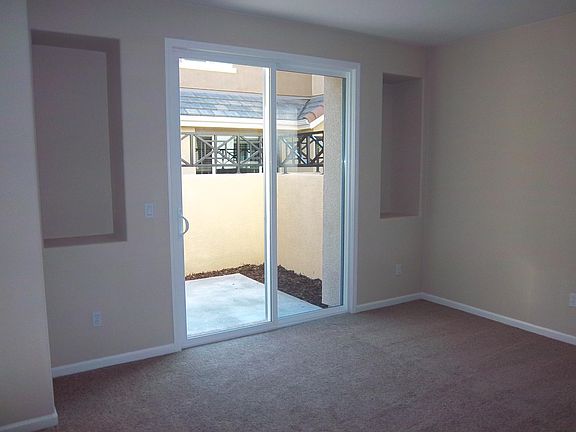 Living area is very sunny with a sliding glass door to patio. This photo was taken in 2013 before landscaping.
