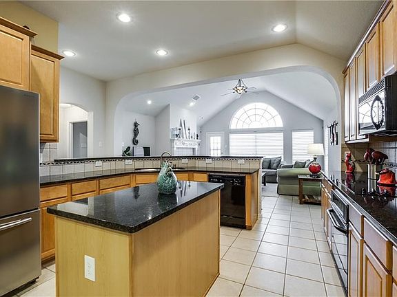 Kitchen has granite and Maple cabinets with 14 ft. ceilings. There is a large pantry behind the frig.