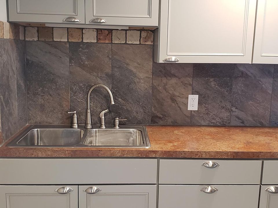 Kitchen with new double stainless steel sink and faucets. New cupboards, counter tops and custom back splash.