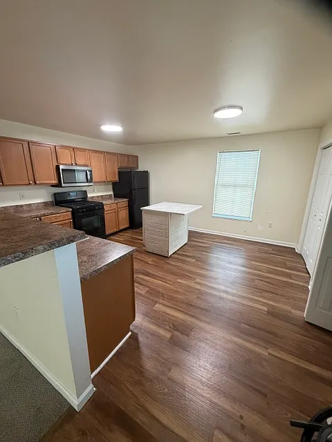 Large eat in kitchen with fridge, microwave, stove, dishwasher, and disposal. Breakfast bar seating.
