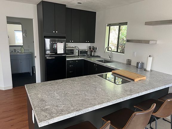 Kitchen with bar, granite countertops, induction cooktop.