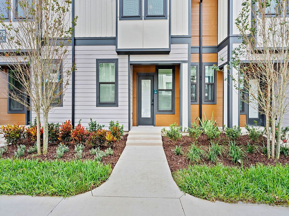 Modern townhouse exterior with sleek design, featuring large windows, landscaped garden, and inviting entrance. Ideal for stylish urban living.