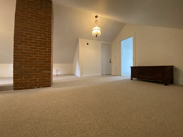 upper level family room/den showing entry door to hall and open doorway to upper bedroom.