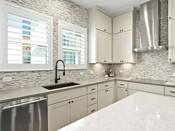 Gourmet kitchen, clean lines, under cabinet lighting, full backsplash, elegant lighting, abundant storage.