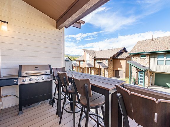 Covered patio with bar seating and a gas grill _ perfect for enjoying mountain views and dining outdoors with family and friends.
