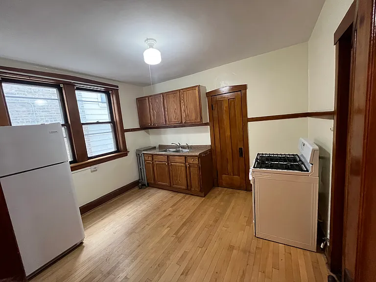 Kitchen with refinished cabinets, includes refrigerator, stove. Door next to sink is large from closet.