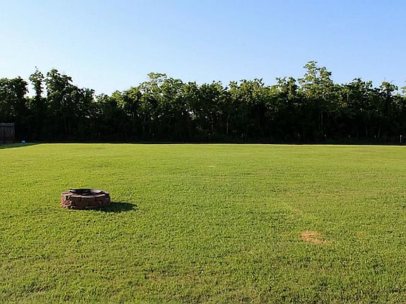 View of the back yard from the house. Wood privacy fencing on both sides with a chain link fence in the back. There's plenty of room here for entertaining your entire family, or for a pool