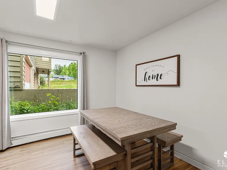 Dining area with large picture window and natural light.