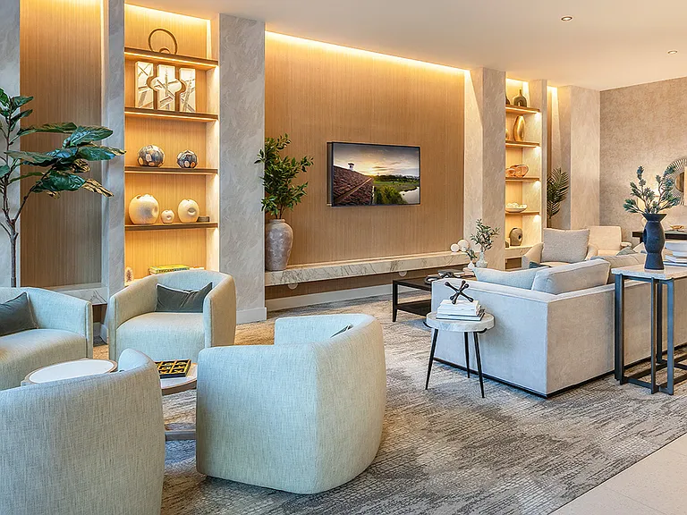 Griffis West Palm apartments resident lounge with plush seating, shelves with decor, and TV.