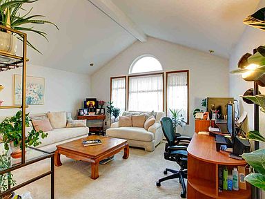 The formal living room has nice vaulted ceilings & neutral color paint & carpeting.